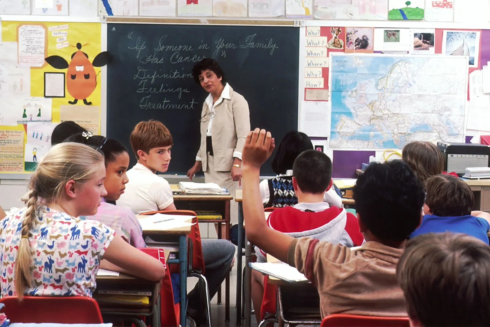 Professora em sala de aula com alunos atentos