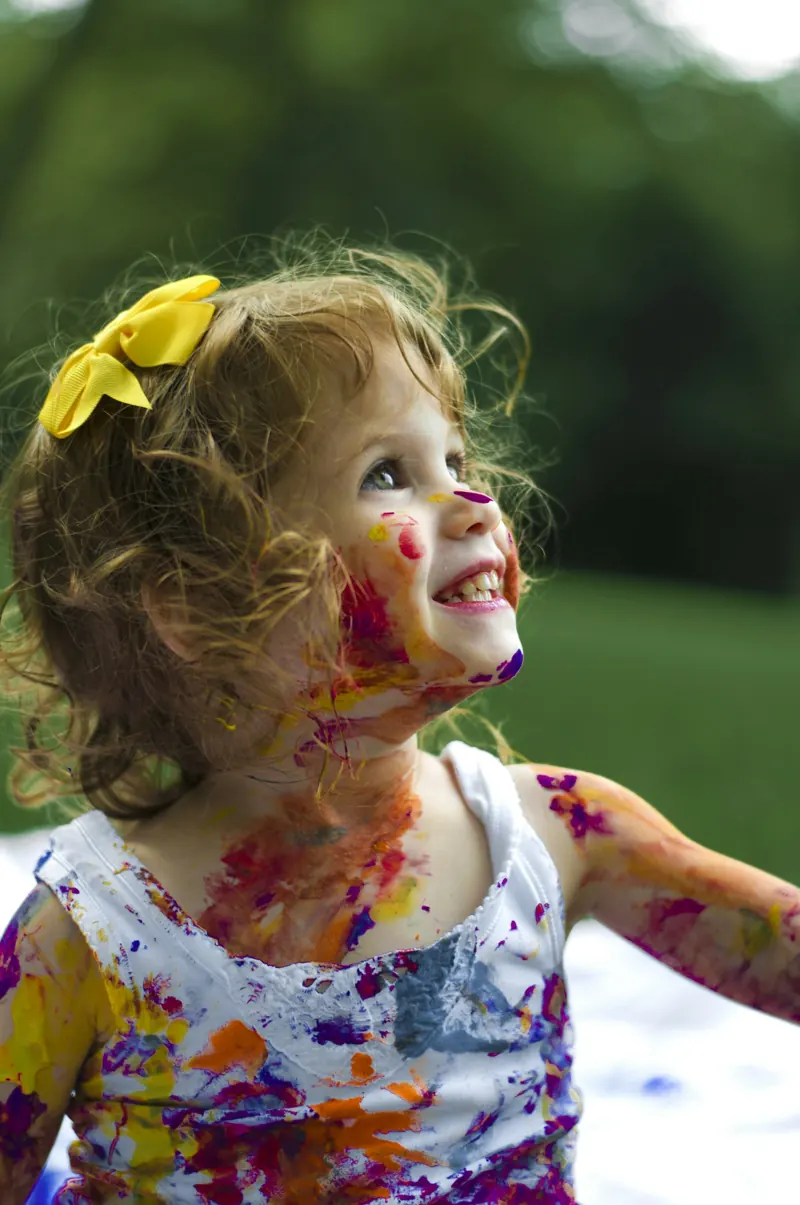 Criança com o rosto pintado em atividade de arte